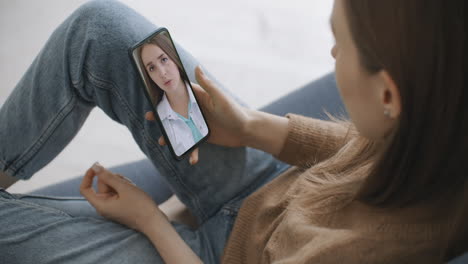 Female-using-online-chat-to-talk-with-family-therapist-and-checks-possible-symptoms-during-pandemic-of-coronavirus.-Woman-using-medical-app-on-smartphone-consulting-with-doctor-via-video-conference.